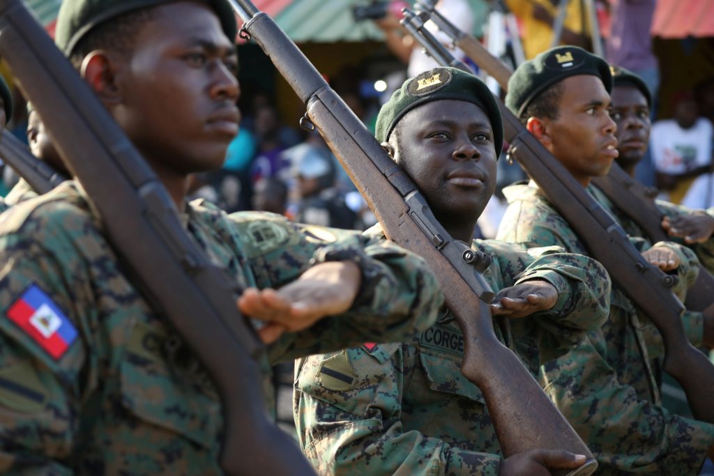 Members of the Haitian Armed Forces (FAD'H) salute as they parade in the streets of Cap-Haitien